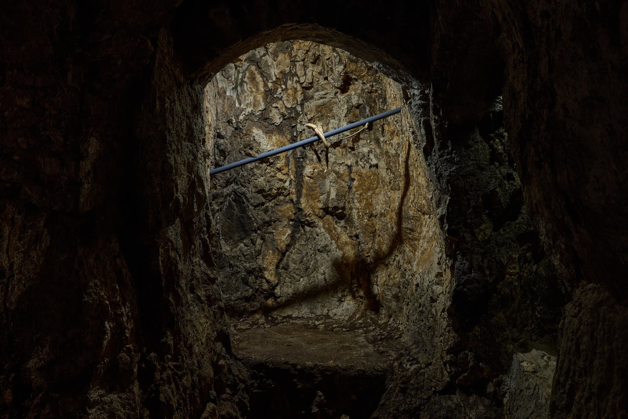 Una nicchia della grotta attraversata da Props di Giovanni Longo, un'asta diagonale smaltata di blu.