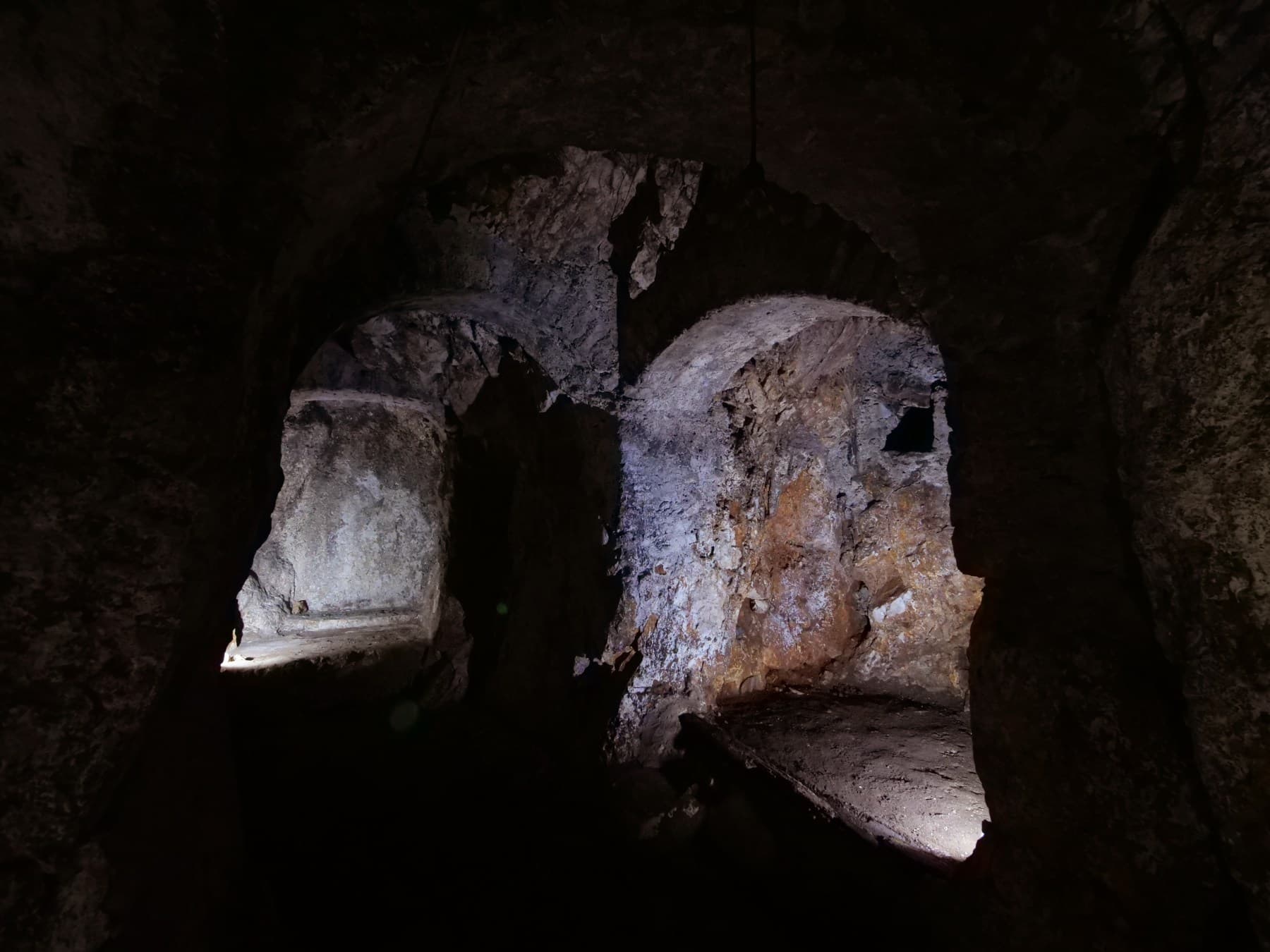 La grotta naturale di Studio Specus: le nicchie e le volte scavate nella roccia, nel buio.