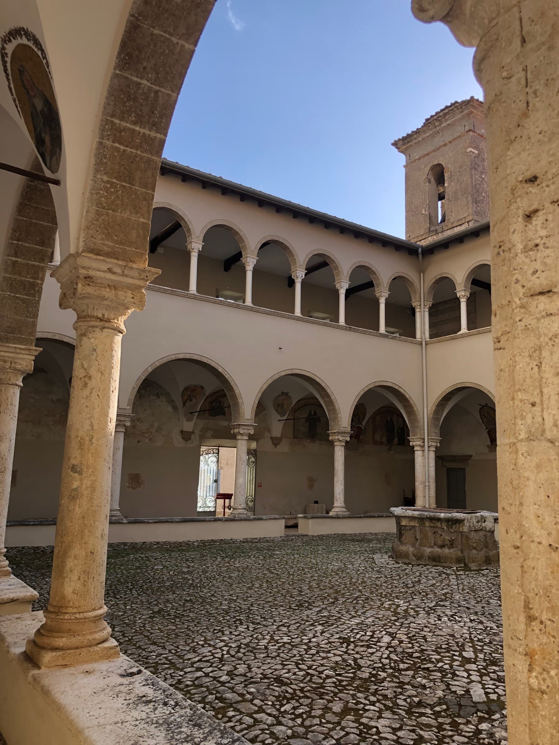Il chiostro luminoso del Museo della Città e del Territorio di Cori, con le arcate rivolte verso il cielo.